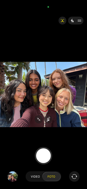 Display di iPhone 17 visto di fronte che mostra un selfie di gruppo scattato usando la funzione Inquadratura automatica per le foto