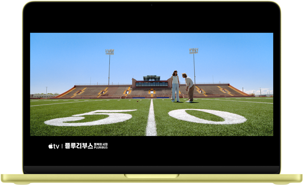 화면에 ‘플루리부스: 행복의 시대’ 프로그램의 장면이 표시된 시트러스 색상 MacBook Neo