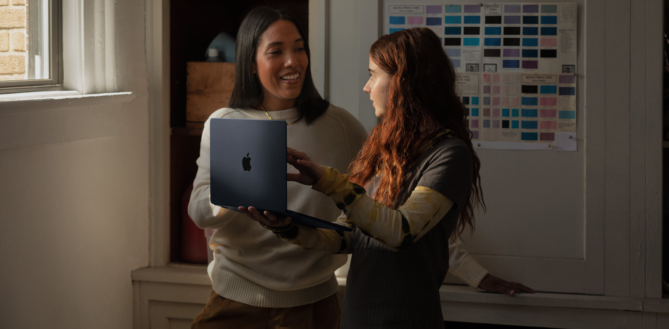 أشخاص يستخدمون Mac في بيئة تعليمية