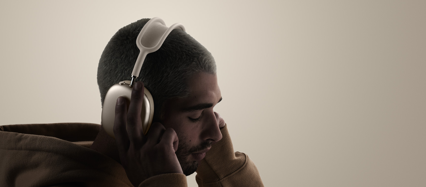Person wearing AirPods Max 2 headphones, side exterior, touching ear cushions